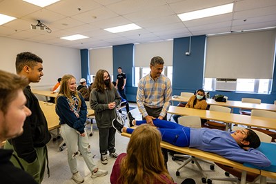 Physical Therapy and Kinesiology Associate Professor Edgar Torres works with UTeach student Mareena Soliman on a biology activity for ninth-graders from Methuen High School.