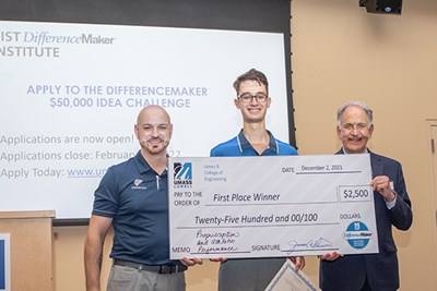 Team Proprioception's Steven Angelos, left, and Mark Elman hold their winning Prototyping Competition check with Dean of Engineering James Sherwood.