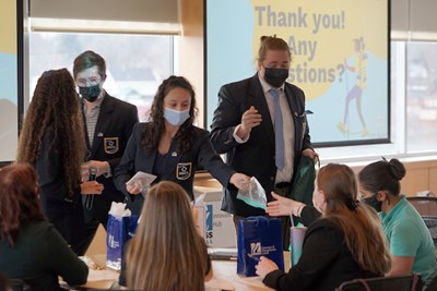 A team of students from Essex North Shore Agriculture and Technical School hand out samples of their ZuMix product to judges during their winning pitch at the DifferenceMaker High School Idea Challenge in Haverhill.