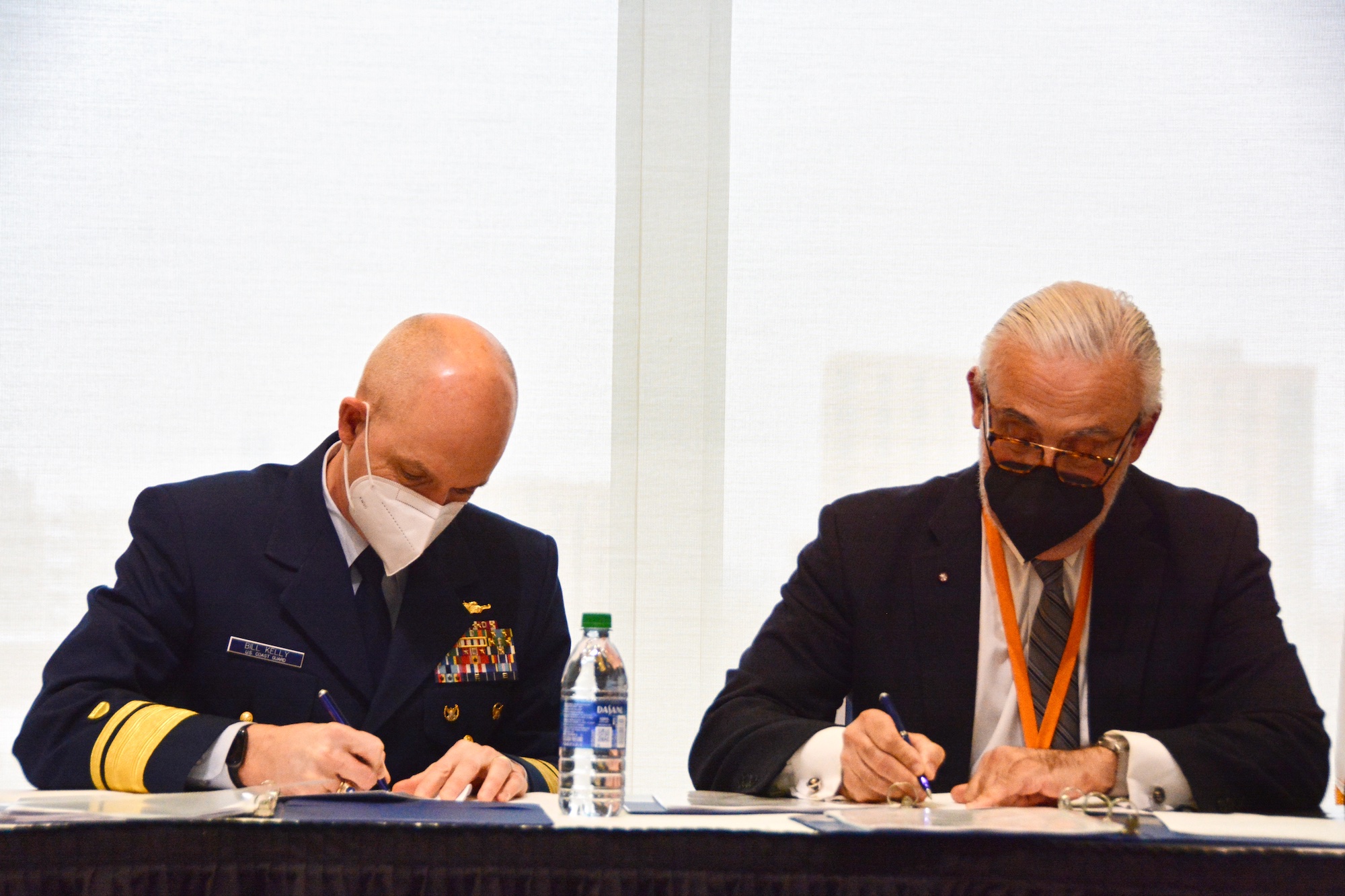 USCGA Superintendent Rear Admiral William Kelly and UMass Boston Chancellor Marcelo Suárez-Orozco sign the agreement on Friday. Image by: Gray Milkowski