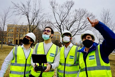 Asst. Prof. Alessandro Sabato points to the drone as he takes it for a test flight with team members, from left, Fabio Bottalico, Marco Angelosanti and Nitin Kulkarni.