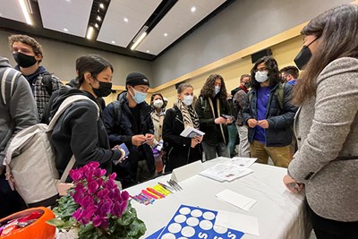 Students gather around the "Ethics and Information Quality" station hosted by Assoc. Prof. of Accounting Karen Lin, right, during Ethics Fest at University Crossing.