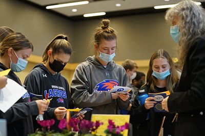 Students learn about the "Ethics of Holiday Gatherings in the COVID-19 Era" at an Ethics Fest station hosted by Campus Minister Imogene Stulken, right.