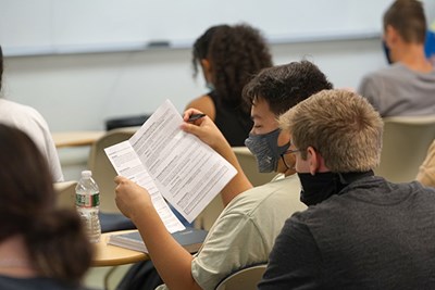 Students look over the syllabus for their Calculus 3 course with Asst. Teaching Prof. Erica Yankowskas on UML's first day back to in-person learning.