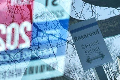 A sign for a reserved carpool parking spot on North Campus is reflected in a car windshield.