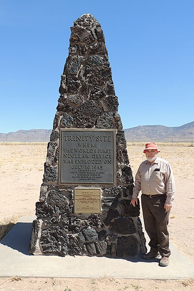 Prof. Nelson Eby poses next to the stone monument marking the Trinity test site’s ground zero, the precise spot where the atomic blast occurred nearly 76 years ago.