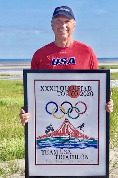 Professor Emeritus Michael E. Jones holds the official Olympic triathlon poster he painted for this year’s Summer Games in Tokyo.