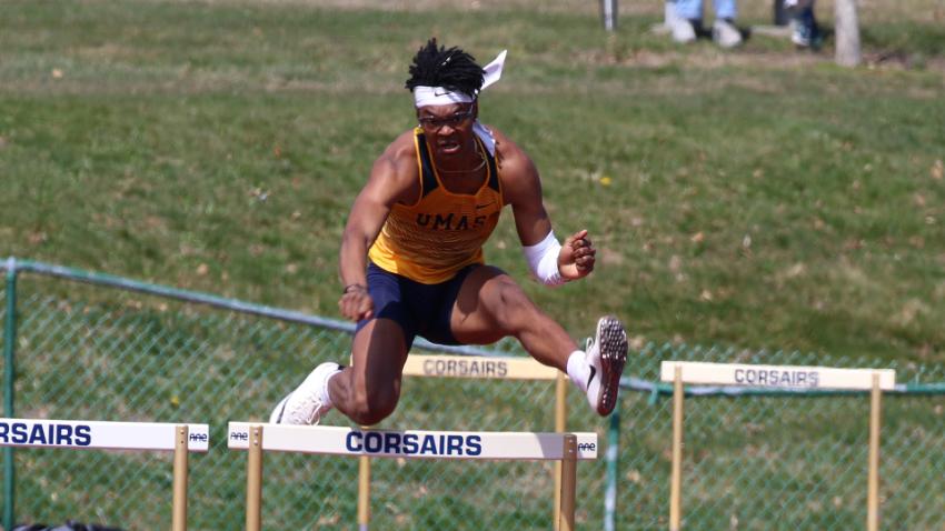 Cameron Rodgers jumps over hurdle during track meet