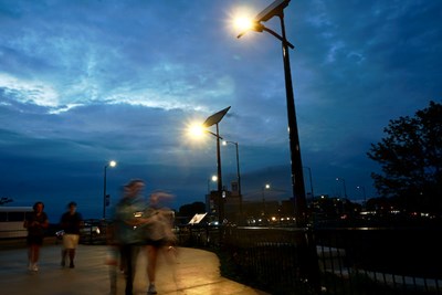 Students walk at dusk under new solar-powered streetlights that the university has installed along the Northern Canal Overlook.