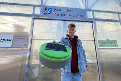 Mechanical engineering major Max Prescott stands in front of entrance of Rist Urban Agriculture Farm