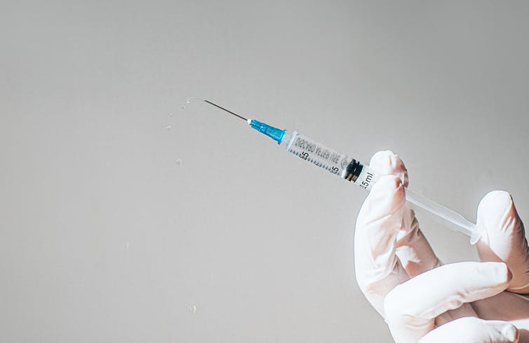 Doctor holds up a syringe