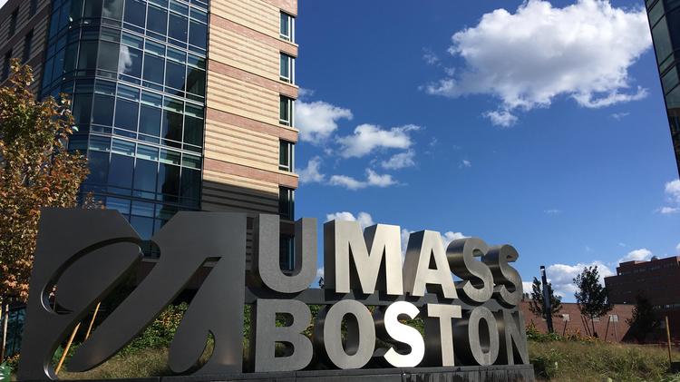 Image of UMass Boston sign in front of dorm building on campus