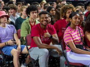 UMass Students in a crowd smile toward the camera