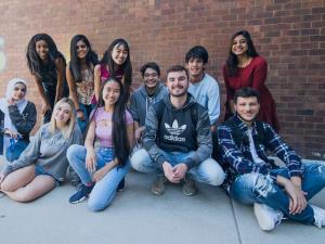 UMass students smiling in a group on campus.