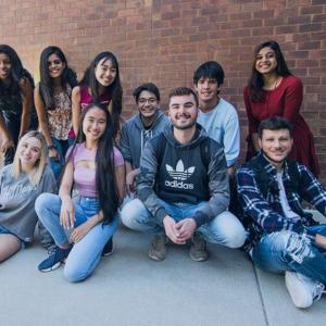 UMass students smiling in a group on campus.