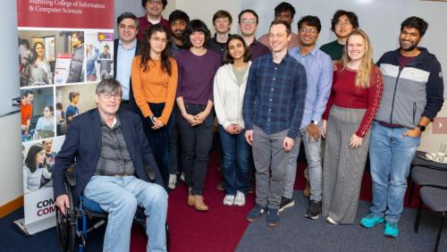 Andrew Barto poses for a photo with CICS students at the ceremony celebrating the announcement of his reception of the Turing Award on March 5, 2025.